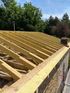 Charpente en bois en cours d'installation sur une toiture lors d'une rénovation effectuée par DGC Couverture.