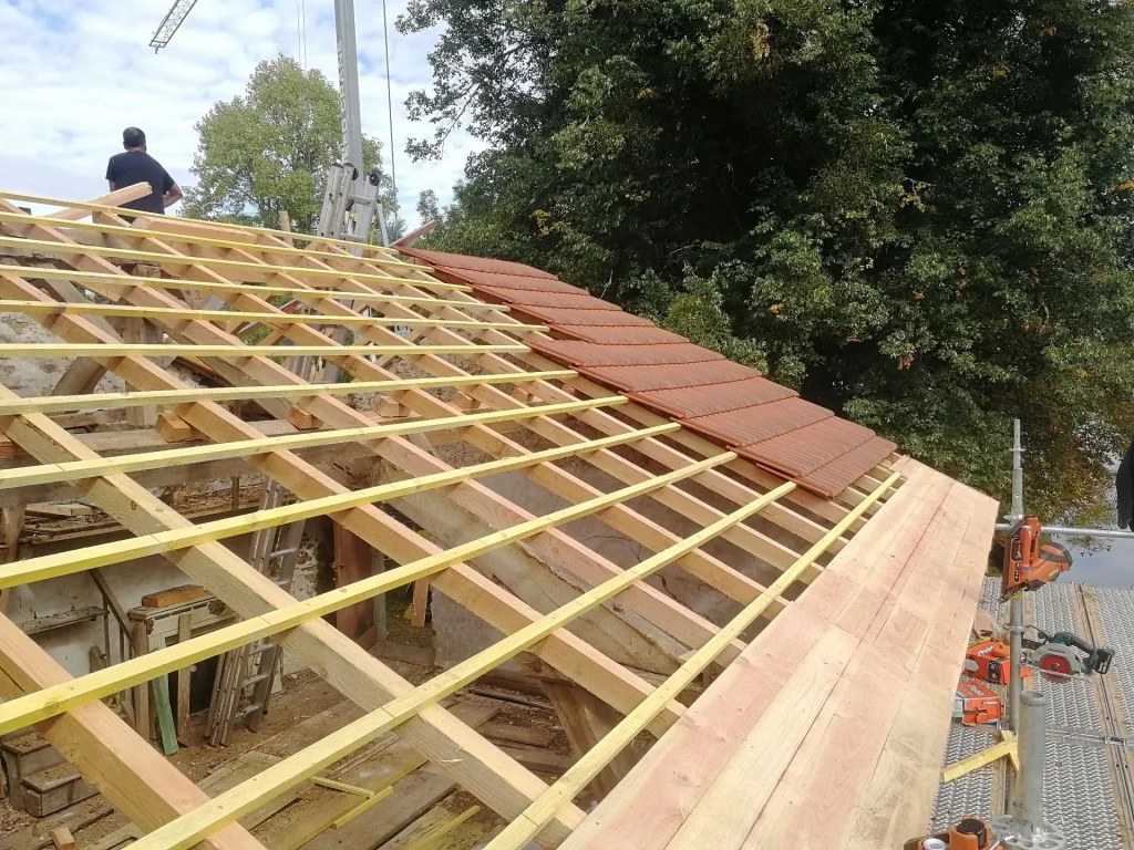 Pose des liteaux et premières tuiles sur une toiture en rénovation à Saint-Priest-Taurion en Haute-Vienne