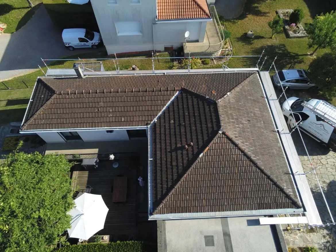 Vue aérienne d’une toiture en tuiles au Palais-sur-Vienne, avec travaux de couverture visibles et échafaudage en place.