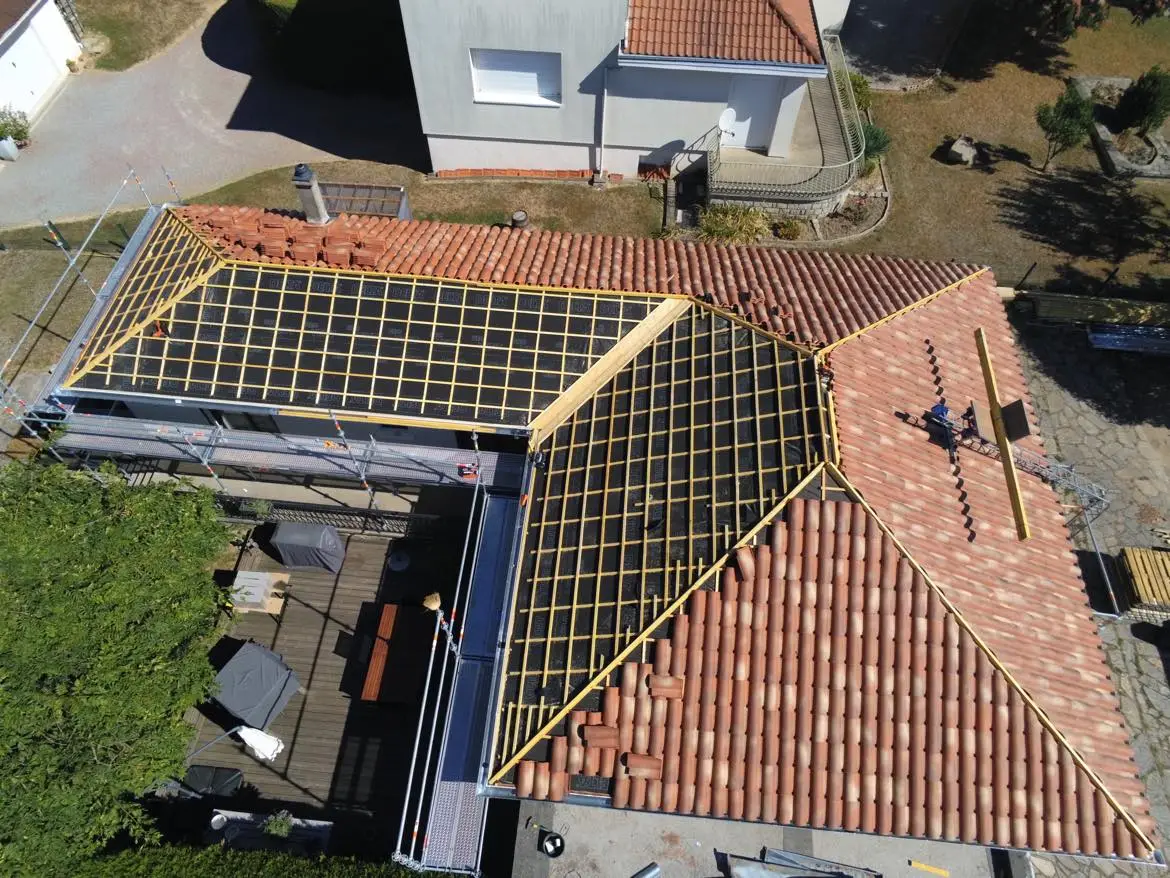 Toiture en tuiles en cours de rénovation au Palais-sur-Vienne, avec liteaux, écran sous-toiture et échafaudage visibles.