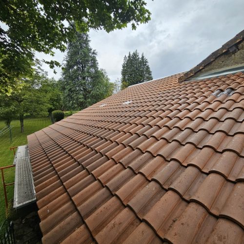 Toiture en tuiles terre cuite rénovée à Limoges (87), versant en pente avec gouttière zinc, vue de près après pluie