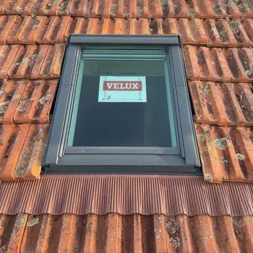 Remplacement d'une fenêtre Velux sur une toiture en tuiles anciennes réalisé par DGC Couverture à Limoges.